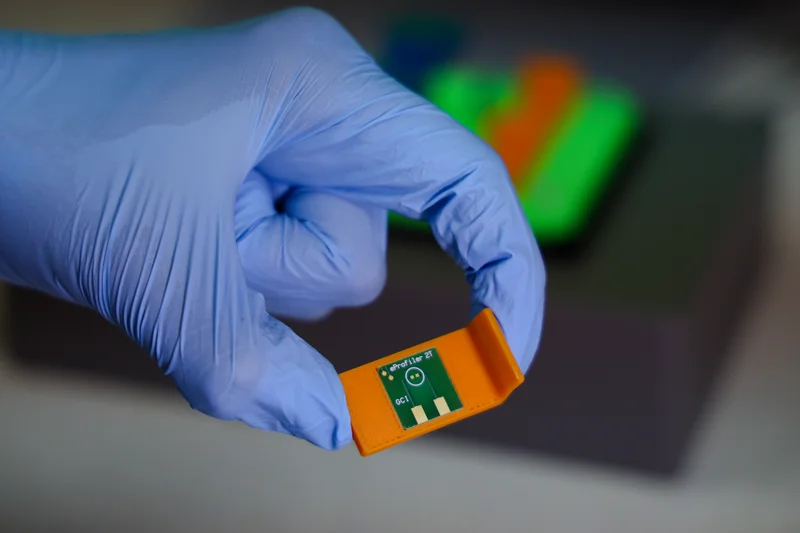 Gloved hand holding eProfiler 2T sensor chip close-up
